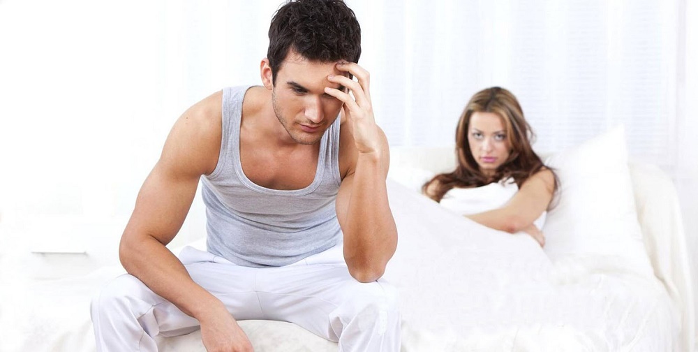 Man upset woman staring while sitting on bed